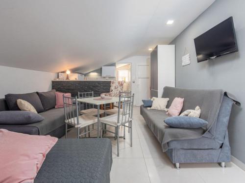 een woonkamer met twee banken en een tafel bij Apartment Sofija-2 by Interhome in Karlobag