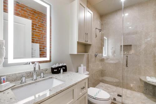 Un baño con lavabo, inodoro y ducha. en New Orleans Luxury Rentals - The Rex, en Nueva Orleans