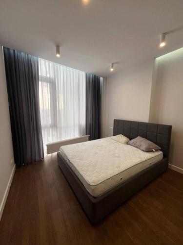 a bed in a bedroom with a large window at Arcadia Studio 238-1 in Odesa
