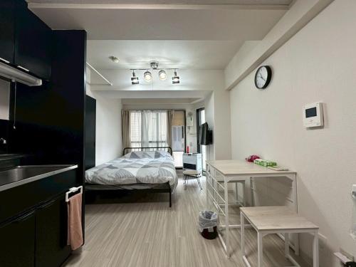 a bedroom with a bed and a kitchen with a table at Residence Hotel #3 窓エアコン 無料Wi-Fi in Kita-rokujō