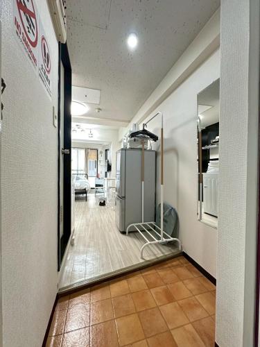 a hallway with a room with a refrigerator in it at Residence Hotel #3 窓エアコン 無料Wi-Fi in Kita-rokujō