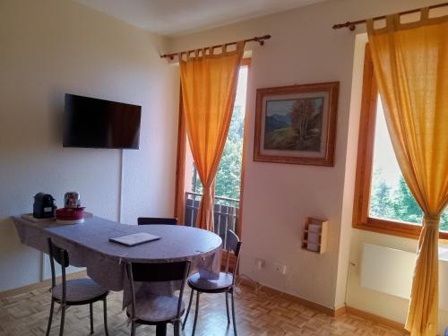 a dining room with a table and two windows at Casaclem in Menconico
