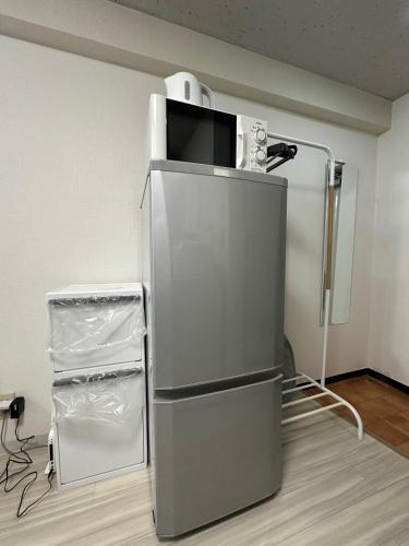 a refrigerator with a microwave on top of it at Residence Hotel #3 窓エアコン 無料Wi-Fi in Kita-rokujō