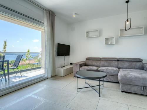 a living room with a couch and a table and a window at Apartment Dita-4 by Interhome in Crikvenica