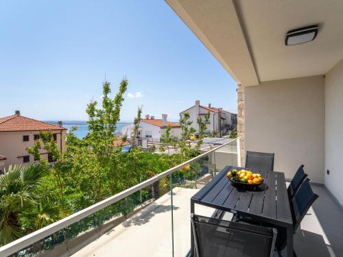 a balcony with a table with a bowl of fruit on it at Apartment Dita-4 by Interhome in Crikvenica