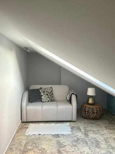 a living room with a couch in a attic at Natura Mierzei 30 - pokoje przy plaży in Krynica Morska