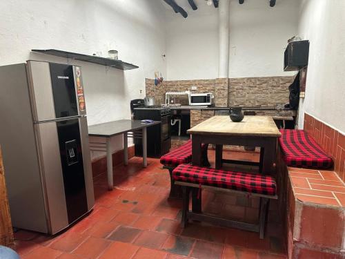 Una cocina con refrigerador y una mesa y sillas. en El Refugio de la Villa, en Villa de Leyva