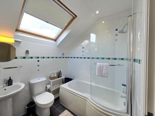 a bathroom with a tub and a toilet and a sink at Cosy 2 Bedroom Apartment With Free Parking in Sheffield