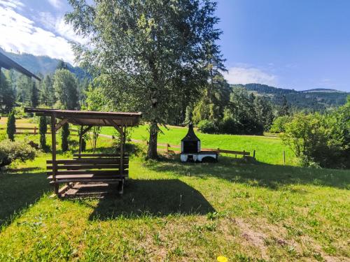 a picnic shelter and a tree in a field at Chalet Altavista by Interhome in Ziano di Fiemme