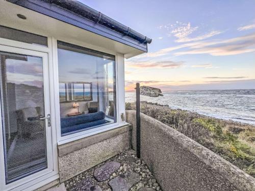 a house with a window looking out at the ocean at Holiday Home Waters Edge by Interhome in Lossiemouth