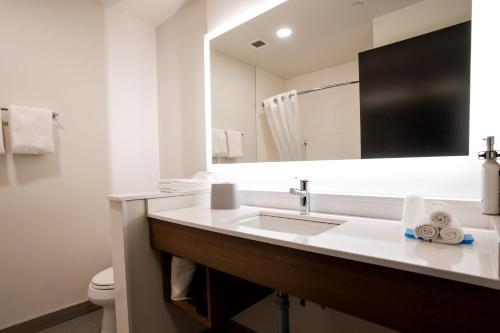 a white bathroom with a sink and a mirror at Holiday Inn Express & Suites - Edmonton SW – Windermere by IHG in Edmonton