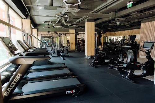 a gym with rows of treadmills and machines at R&M Residence in Pécs