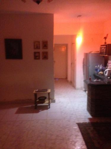 a kitchen with a refrigerator and a table in a room at Fantastic Chalet ,North coast in Dawwār ‘Abd Allāh