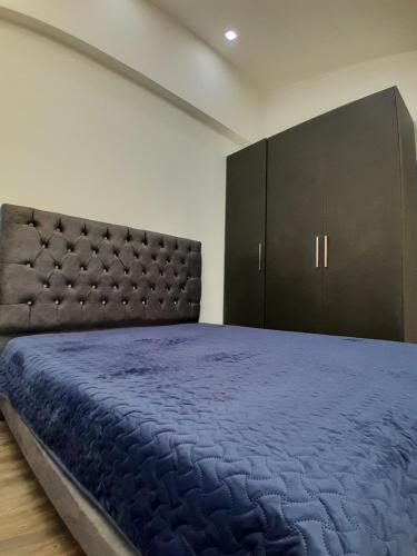 a bedroom with a large bed with a large headboard at Suite de 3 camas cerca a la UTPL in Loja