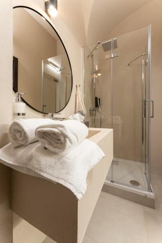 a bathroom with a sink with a mirror and a shower at Aparthotel Lavilo Main Square in Graz