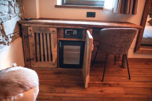a wooden table with a microwave in a room with a chair at Ca d' Vetu in Roccaforte Mondovì