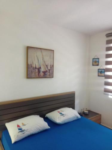 a bedroom with a blue bed with two white pillows at Anika in Sutomore