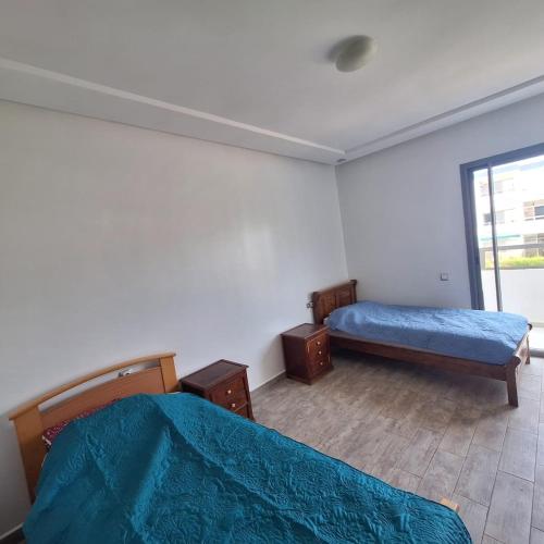 a bedroom with two beds and a window at Appartement marbella beach in Mansouria