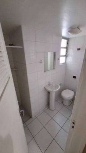 a white bathroom with a toilet and a sink at Vicz Palace Hotel in Curitiba