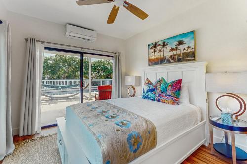 a bedroom with a bed and a sliding glass door at Makena in Koloa