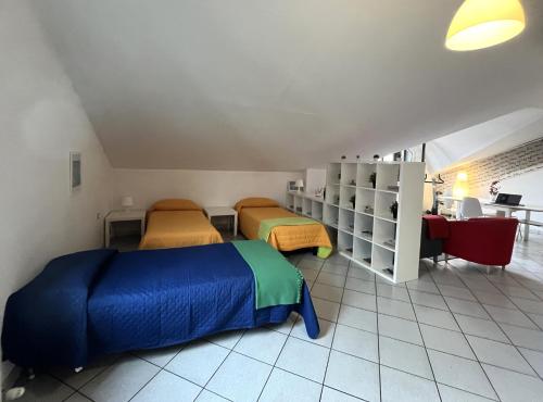 a room with two beds and a table and a desk at Loft in Fiera in Pregnana Milanese