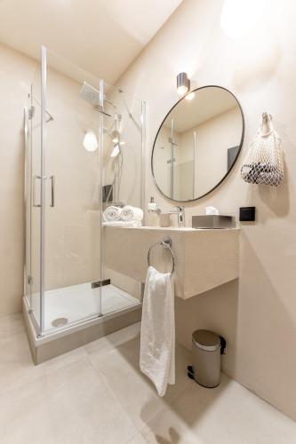 a bathroom with a shower and a sink and a mirror at Aparthotel Lavilo Main Square in Graz