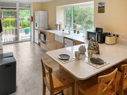 a kitchen with a table and chairs and a refrigerator at River View Sanctuary - Uk47338 in Pateley Bridge
