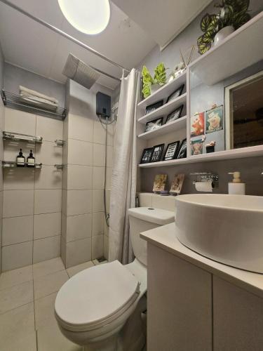 a white bathroom with a toilet and a sink at Zen Vibes Modern 2BR Asian Fusion Stay in Manila