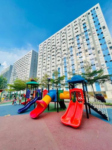 a playground with colorful slides and play equipment in a city at Zen Vibes Modern 2BR Asian Fusion Stay in Manila