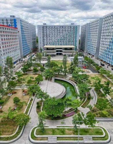 a park in a city with tall buildings at Zen Vibes Modern 2BR Asian Fusion Stay in Manila