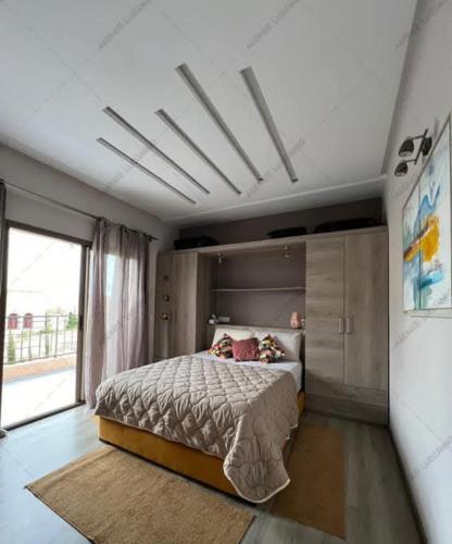 a bedroom with a bed and a large window at Villa Rose du désert in Essaouira