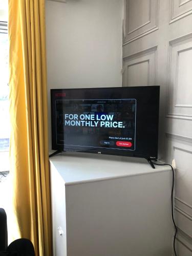 a flat screen tv sitting on top of a refrigerator at Little apartment 20 min from central London in London