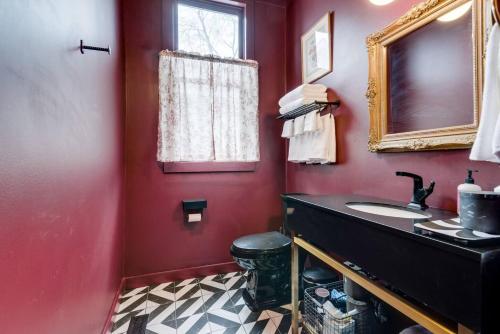 a red bathroom with a sink and a mirror at Chic 2 Bed 2 Bath, In 12 South in Nashville
