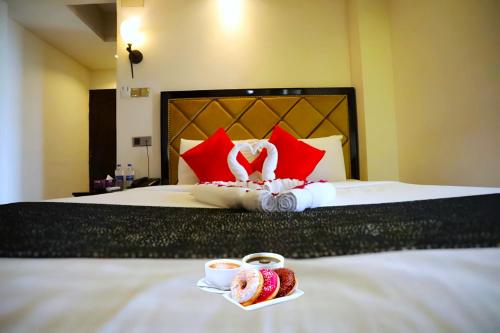 a hotel bed with two cups of coffee and sushi at The Elite Residence Dhaka in Dhaka