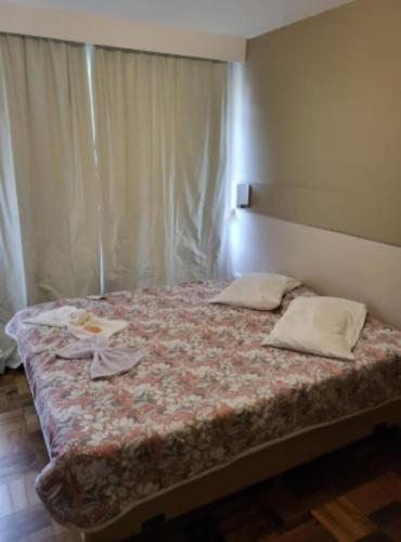 a bed with two pillows on it in a room at Vicz Palace Hotel in Curitiba
