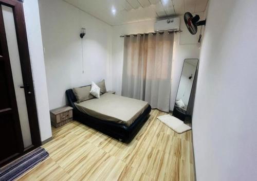a small bedroom with a bed and a mirror at Zilwest Villa in Flic-en-Flac