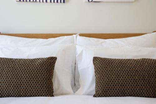 a group of pillows on a bed with white pillows at Casas do Picoto in Chaves