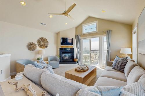 a living room with two couches and a fireplace at Alluvial Shores in Rockaway Beach