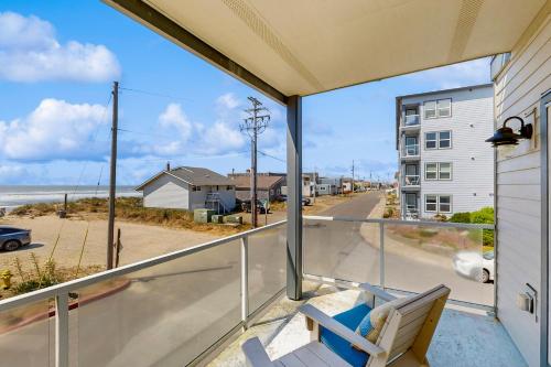a balcony with a chair and a view of the ocean at Alluvial Shores in Rockaway Beach