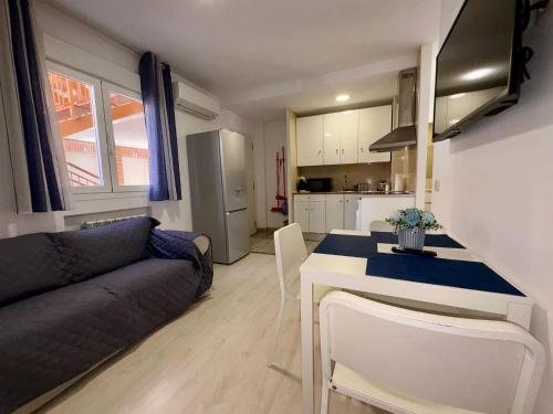 Una cocina y una sala de estar con un sofá y una mesa. en Noria 1B Derecha 3PERSONAS, en Alcalá de Henares