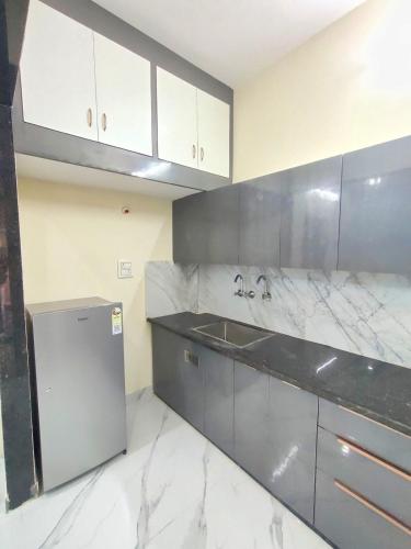 a kitchen with white marble counter tops and a refrigerator at Elegant & Spacious Venue in Kota
