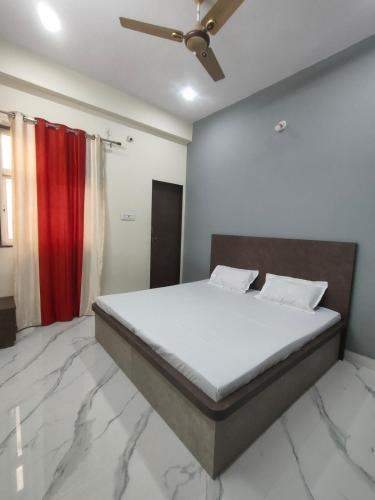 a bedroom with a bed and a red curtain at Elegant & Spacious Venue in Kota
