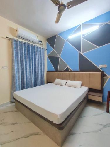 a bedroom with a bed and a blue wall at Elegant & Spacious Venue in Kota