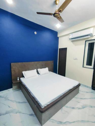 a bed in a room with a blue wall at Elegant & Spacious Venue in Kota