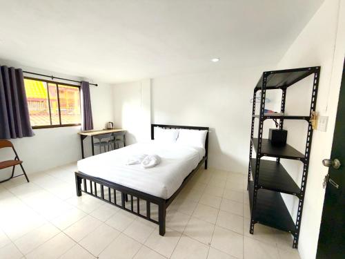 a bedroom with a bed and a book shelf at Patong Canal Villa R203 in Patong Beach