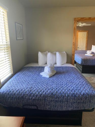 a bedroom with a bed with a teddy bear on it at Scarborough Inn in Manteo