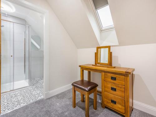 a bathroom with a vanity and a mirror and a stool at Fiadh Ruadh-Uk40008 in Gartmore