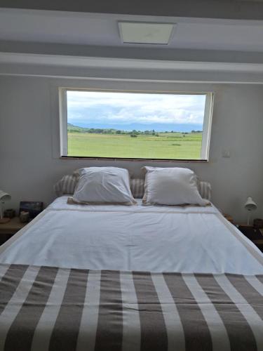 a bedroom with a large bed with a large window at Duplex piscine calme in Vendémian