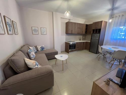 salon z kanapą i stołem oraz kuchnią w obiekcie AnBel Harmony Stay w mieście Golem