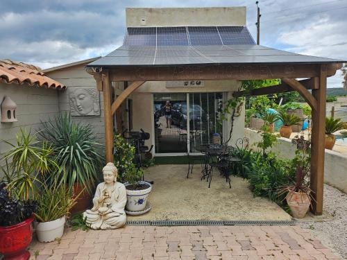 a gazebo with a statue in front of a house at Duplex piscine calme in Vendémian